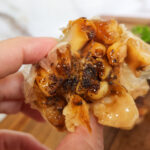 A head of freshly oven roasted garlic being held
